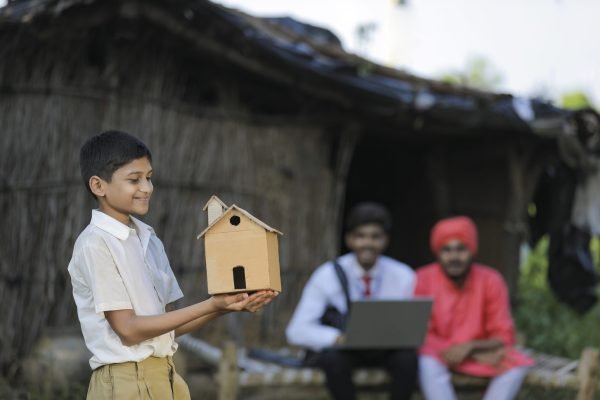 Dream home concept : poor farmer little child holding handmade home in hand